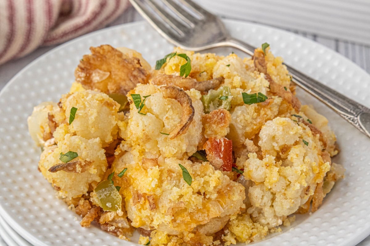 Closeup of a plate of cauliflower casserole with a fork nearby.