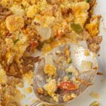 Cheesy Southern cauliflower casserole with crispy cornbread topping and fried onions in a white baking dish with bold red text overlay.