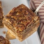 Brown butter pecan pie bar on a silver serving spoon.