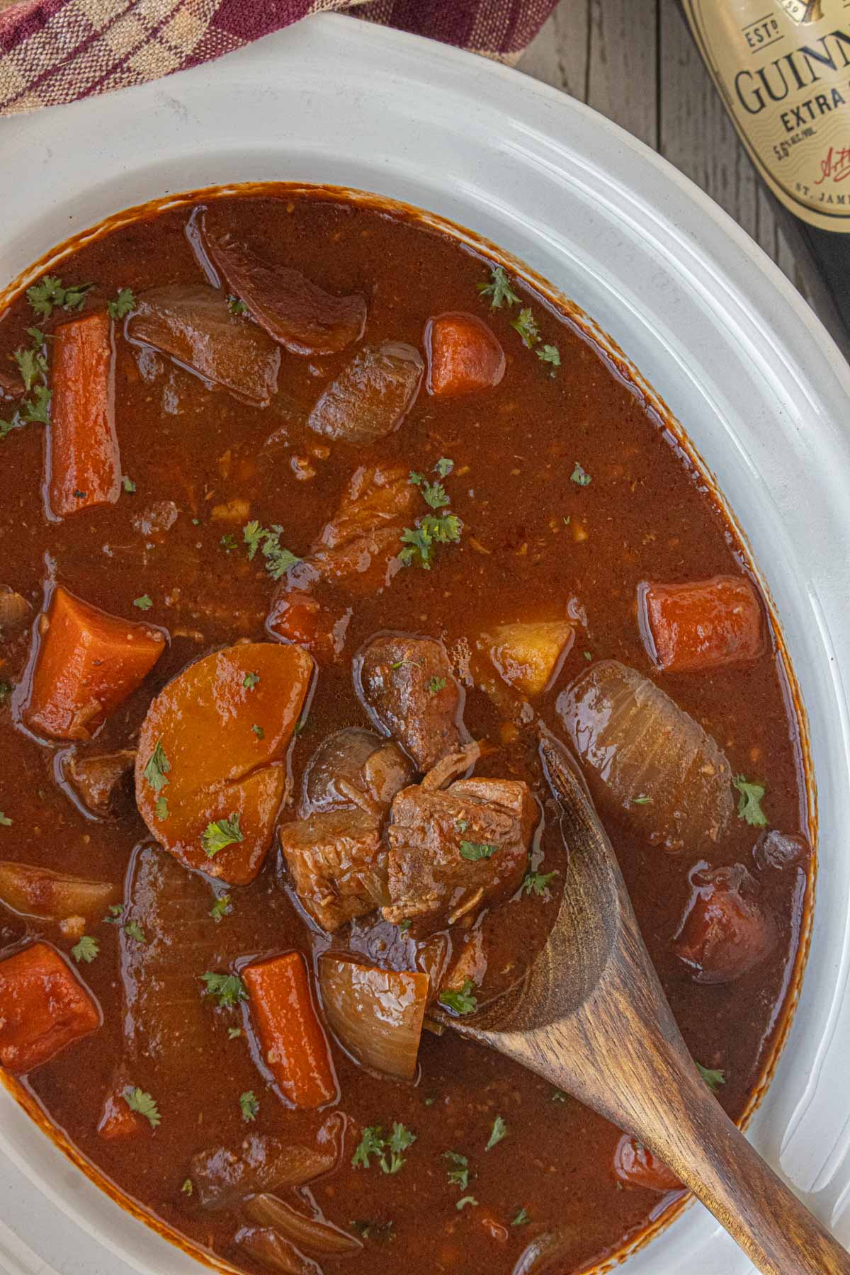 Slow cooker Guinness beef stew with tender beef, carrots, potatoes, and onions in a rich dark broth