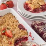 Baked strawberry cream cheese dump cake in a white baking dish with crumb topping and strawberry filling, shown with serving spoon and plated portions. Text overlay for Pinterest.