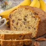 Banana date bread sliced and stacked on a cutting board ready to serve.