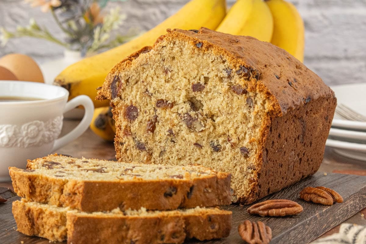 Banana date bread sliced and stacked on a cutting board ready to serve.