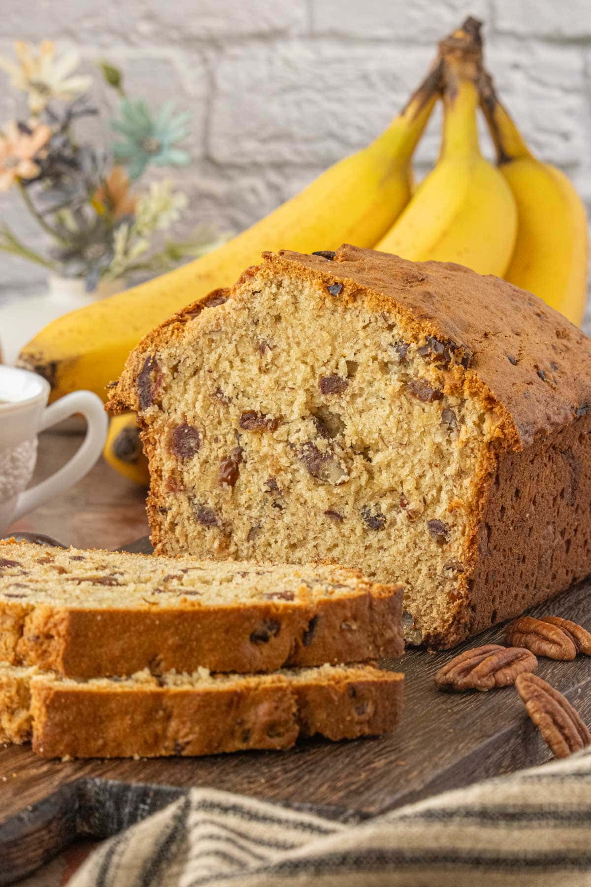 Close-up of banana date bread loaf sliced to reveal soft crumb and caramelized dates.