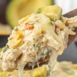 Easy skillet enchiladas suizas with creamy chicken, melted cheese, and avocado on a spoon with text this is not a salad night.