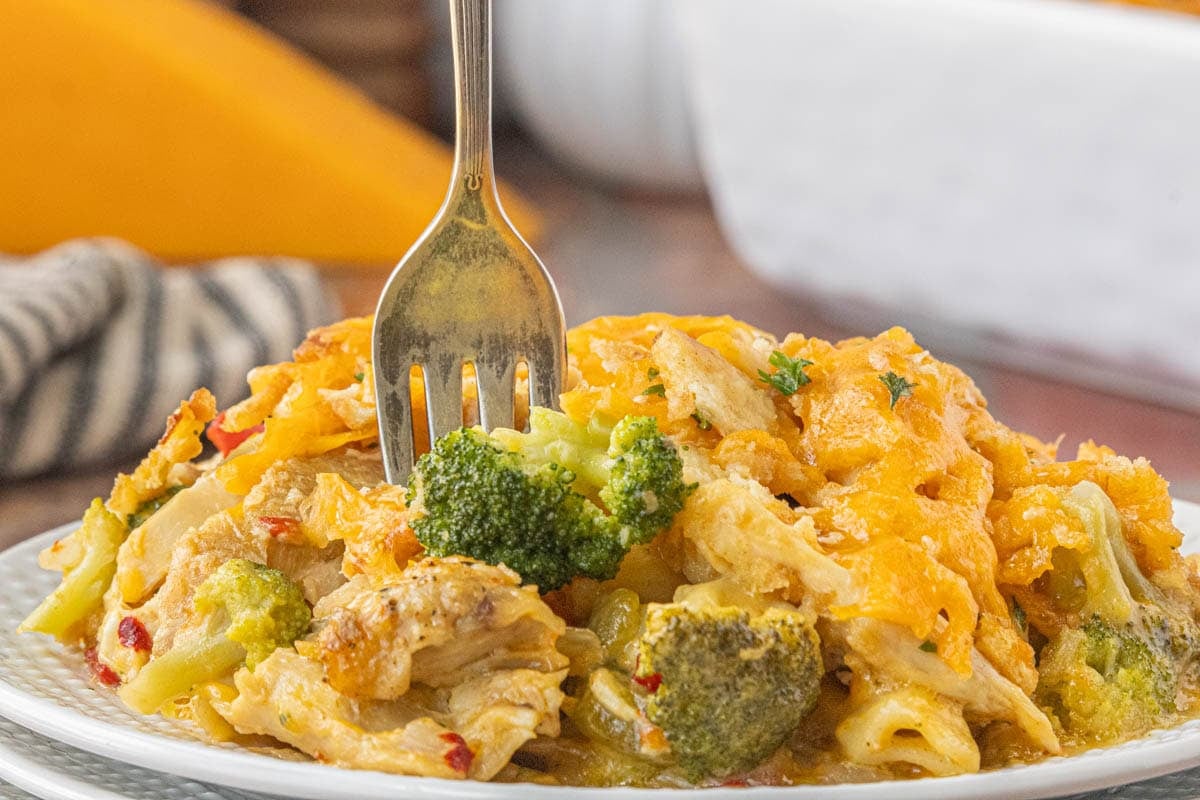 Pimento cheese chicken casserole served on plate with broccoli chicken and cheesy pasta.