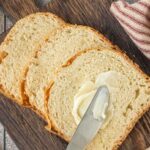 Slices of Amish white bread just out of the bread machine with overlay text for Pinterest.