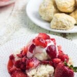 A plate with strawberry shortcake made with 3-ingredient cream soda biscuits. Text overlay for Pinterest.