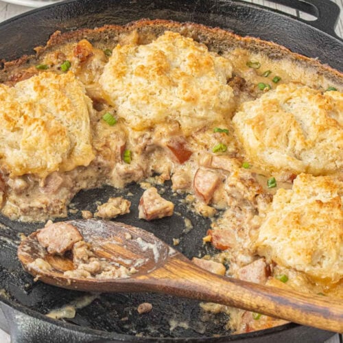Biscuits and gravy pot pie with smoked sausage and homemade biscuits baked in a cast iron skillet