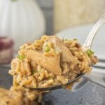 A spoonful of stick of butter chicken and rice being lifted from the skillet with text overlays for Pinterest.
