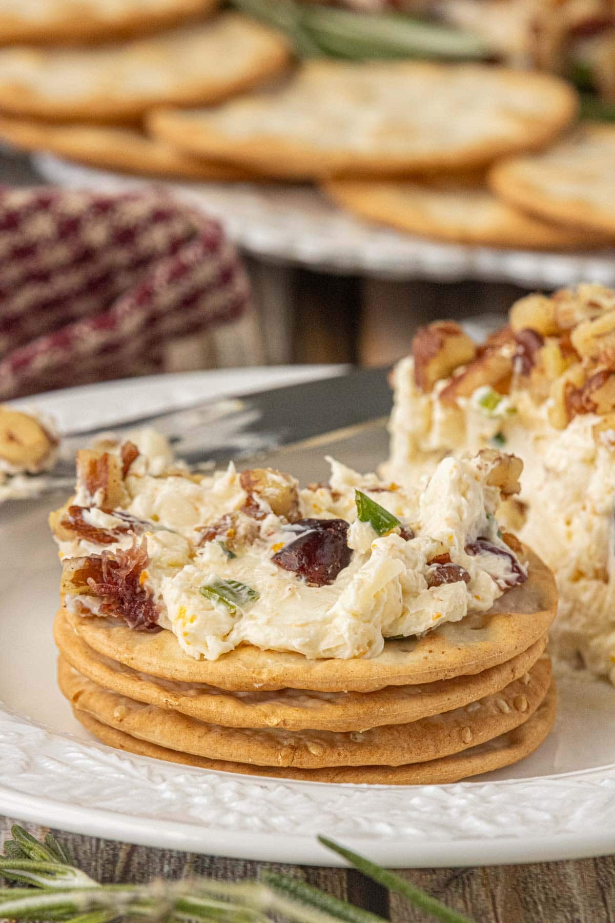 Cranberry cheese ball spread on a round cracker showing the creamy texture and dried cranberries.