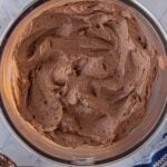 Pinterest pin for homemade chocolate fudge frosting with the text "Oops... Ate Half." The pin features a bowl of rich chocolate fudge frosting with the title "Chocolate Fudge Frosting."