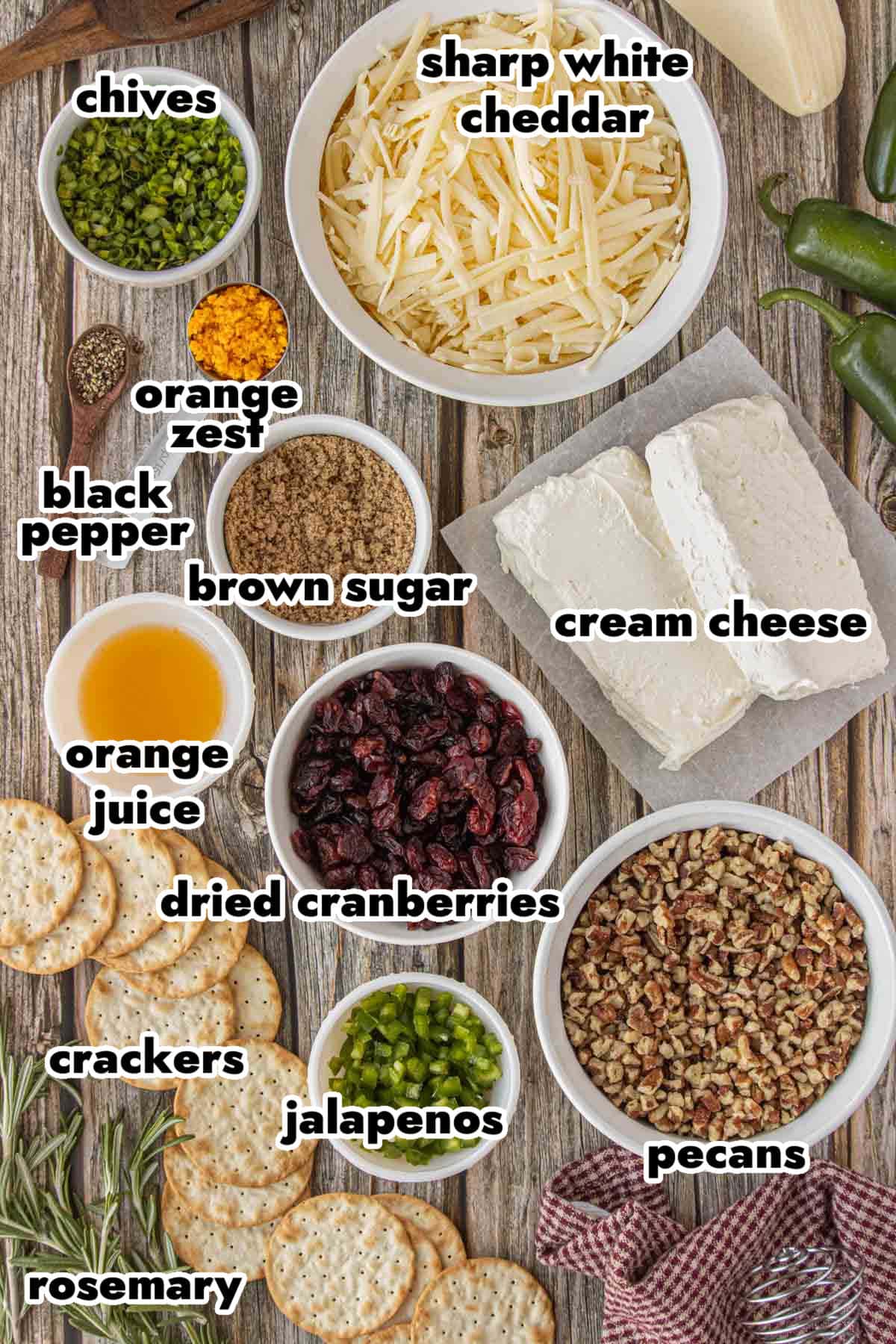 Ingredients for cranberry cheese ball wreath including cream cheese, cheddar, dried cranberries, pecans, jalapeños, chives, and orange zest.