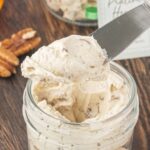 A butter knife holding a generous serving of pecan praline honey butter with text overlay for Pinterest.