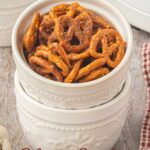 Pinterest pin for slow cooker taco pretzels featuring a white bowl filled with seasoned pretzels stacked on white ramekins. Text reads, "Make Extra. Trust Me." and "Slow Cooker Taco Pretzels."
