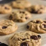 Brown butter chocolate chip cookies with gooey dark chocolate on a cooling rack with text overlay for Pinterest.