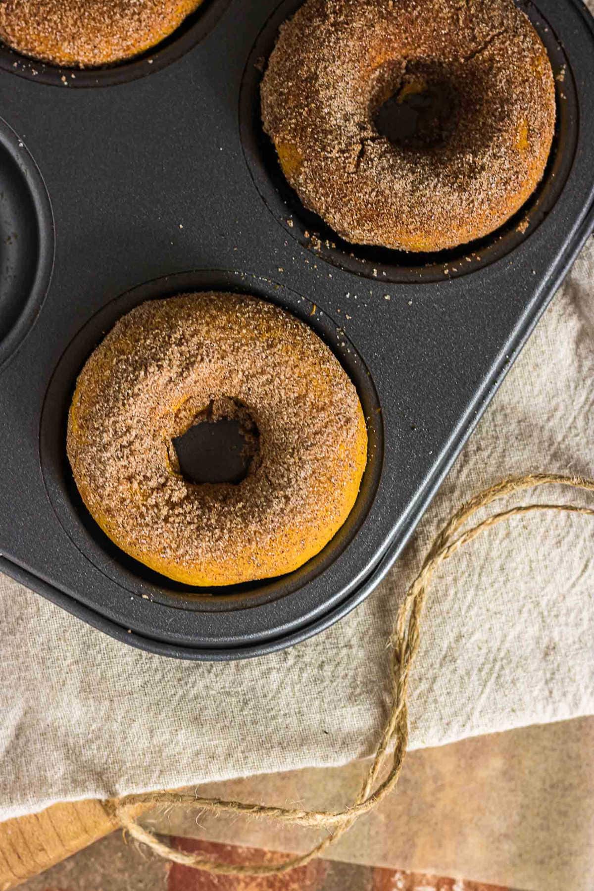 Freshly baked pumpkin spice donuts with cinnamon sugar in a donut pan