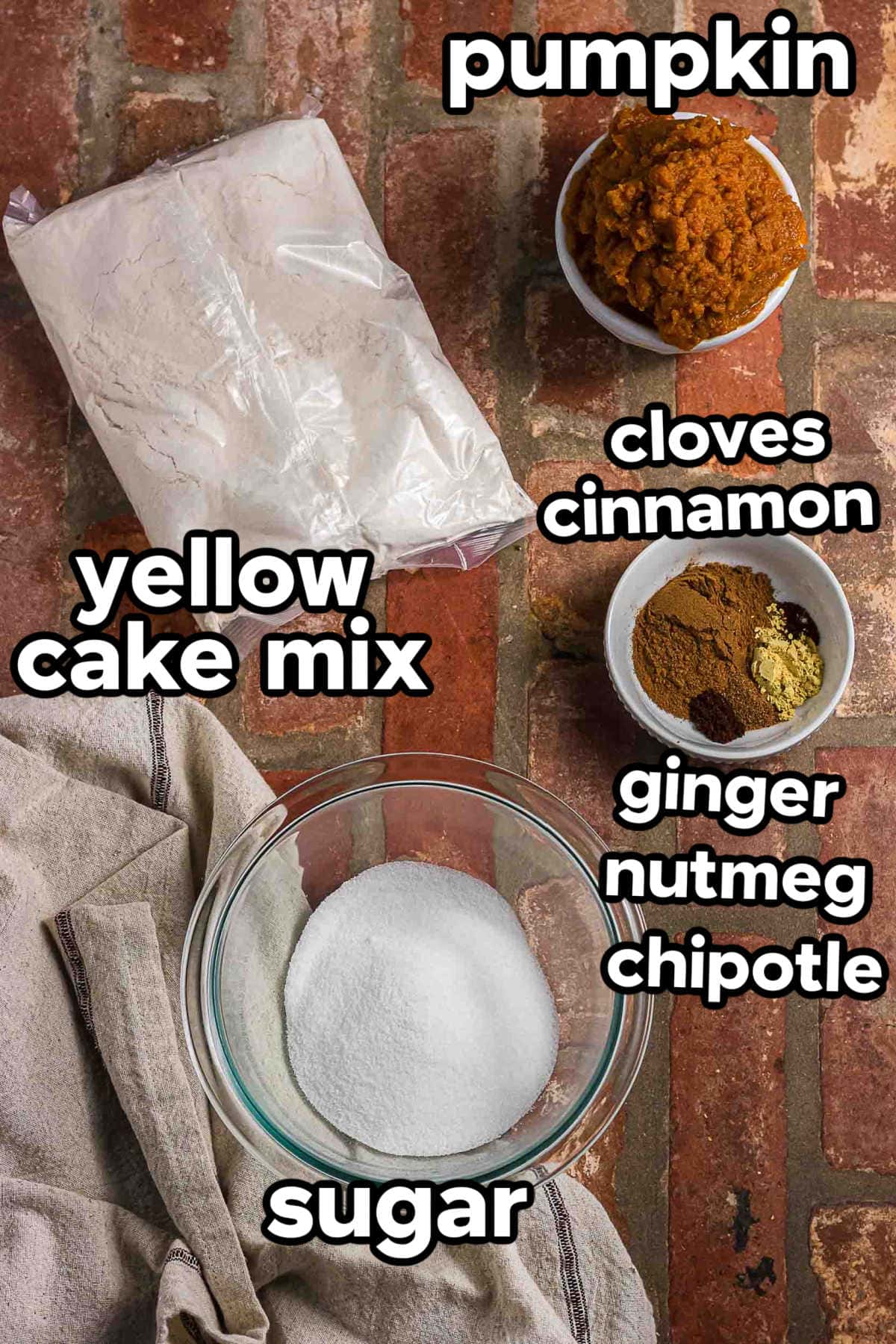 Ingredients for pumpkin donuts with cake mix, pumpkin, sugar, cinnamon, cloves, ginger, nutmeg, and chipotle