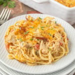 Serving of creamy BBQ chicken spaghetti casserole with shredded chicken, Rotel tomatoes, and smoked Gouda on a white plate