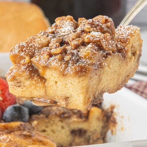 Brown Butter Praline French Toast Casserole with a gooey pecan brown sugar topping and a dusting of powdered sugar.