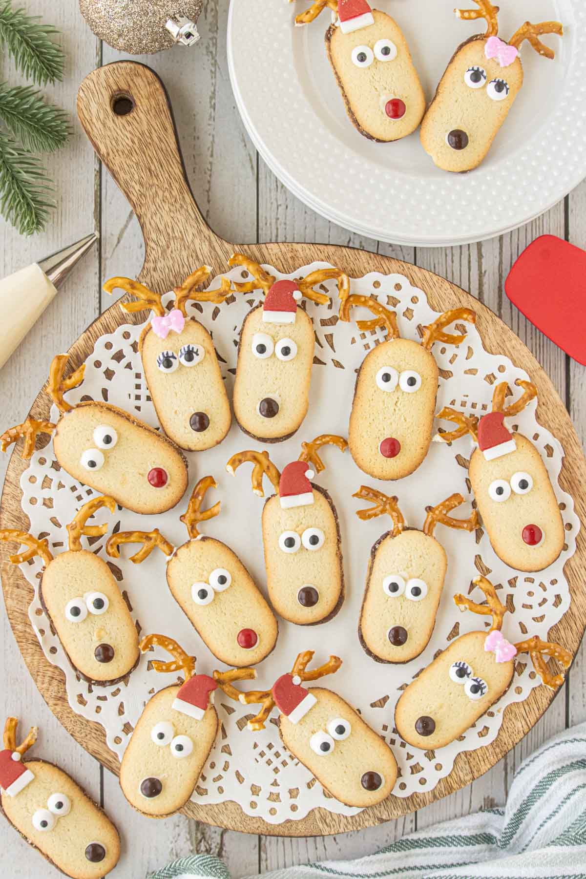Christmas reindeer cookies made with Milano cookies, pretzel antlers, candy eyes, and M&M noses