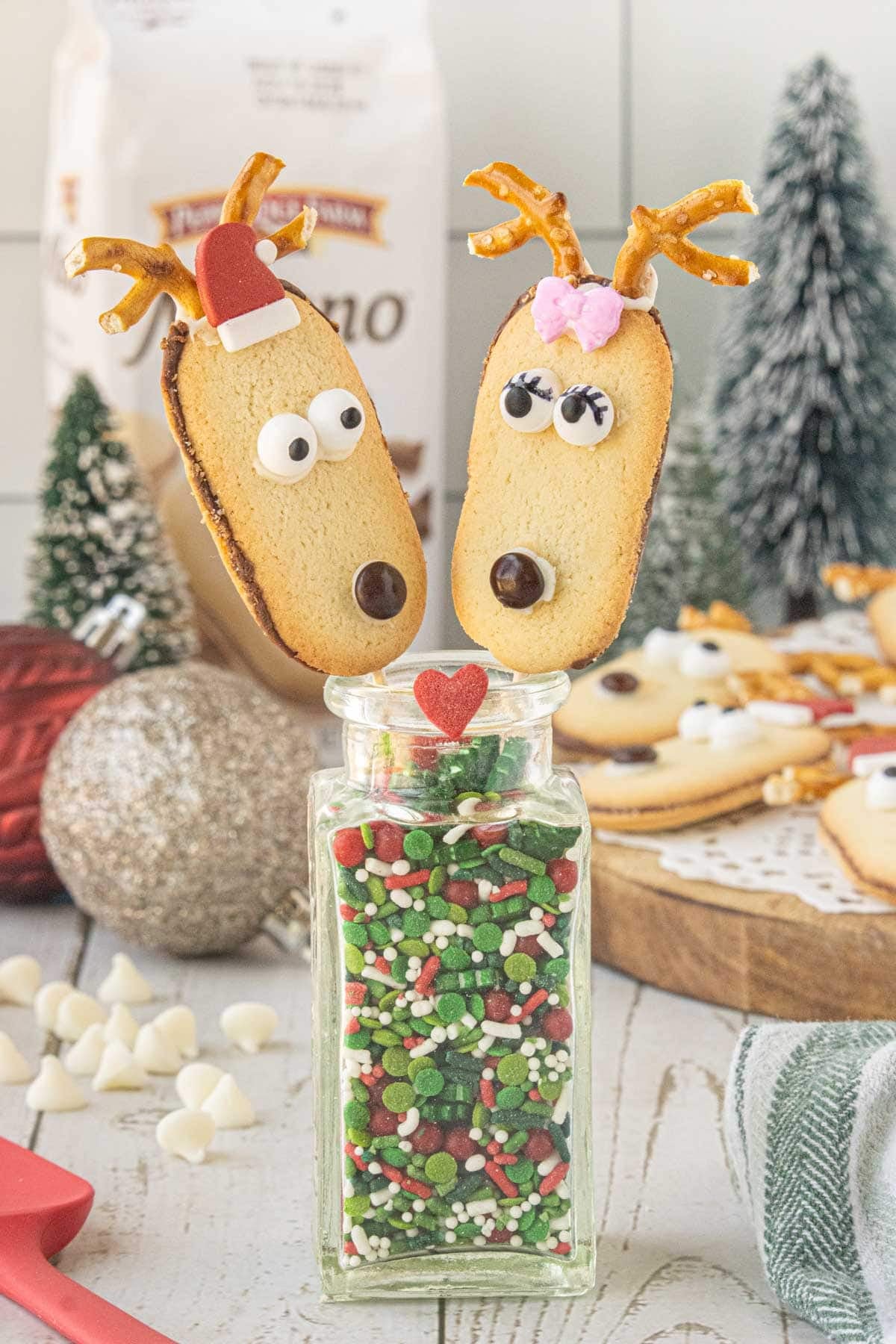 Easy Milano reindeer cookies with pretzel antlers and candy decorations for Christmas