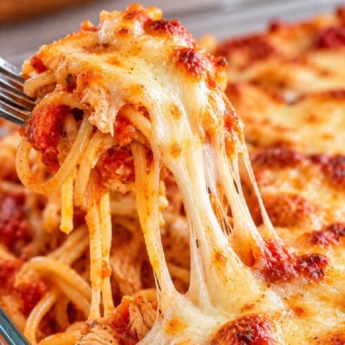 Baked chicken spaghetti with red sauce and a gooey melted mozzarella cheese pull.