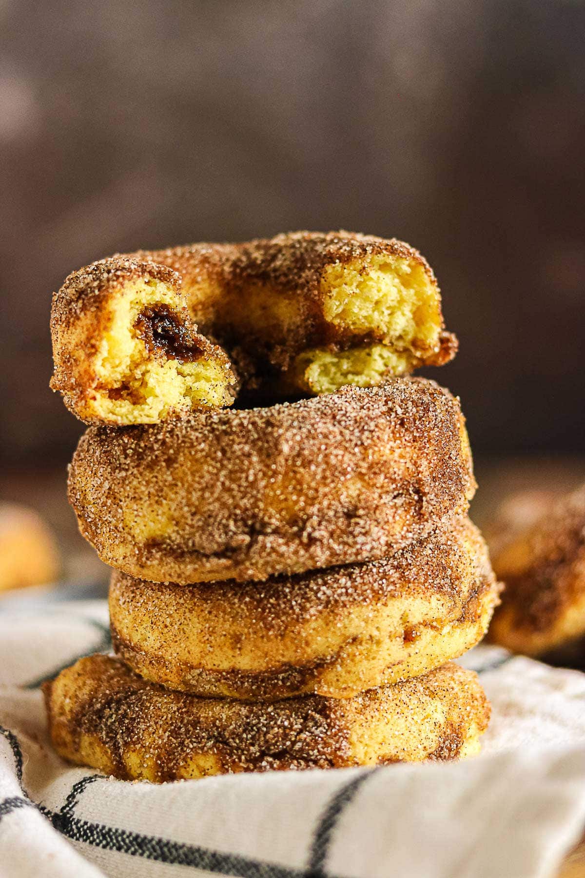 Stack of cinnamon baked donuts with a broken donut showing the brown sugar cinnamon filling