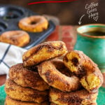 Cinnamon baked donuts coated in cinnamon sugar with a gooey brown sugar cinnamon swirl, stacked on a green plate.