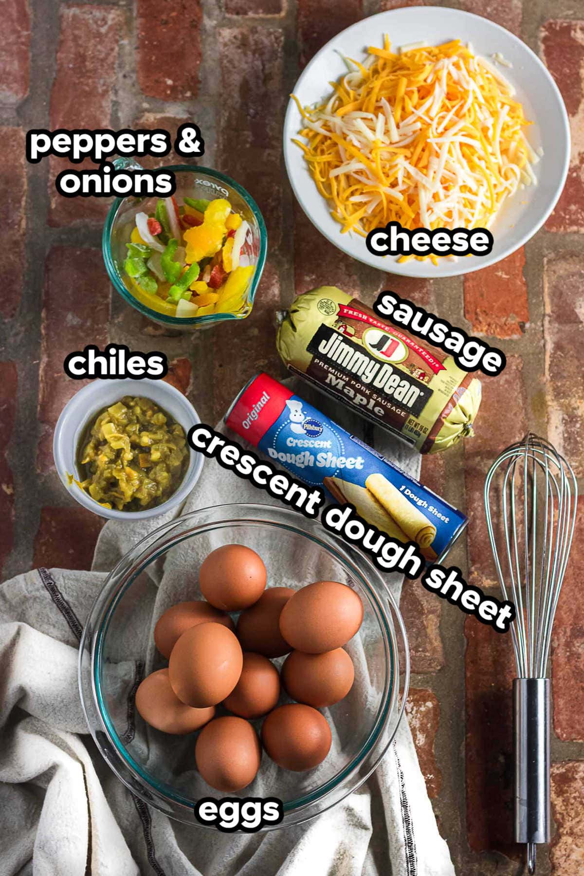 Ingredients for the crescent roll breakfast casserole include crescent roll sheets, eggs, sausage, peppers, onions, chiles, and cheese.