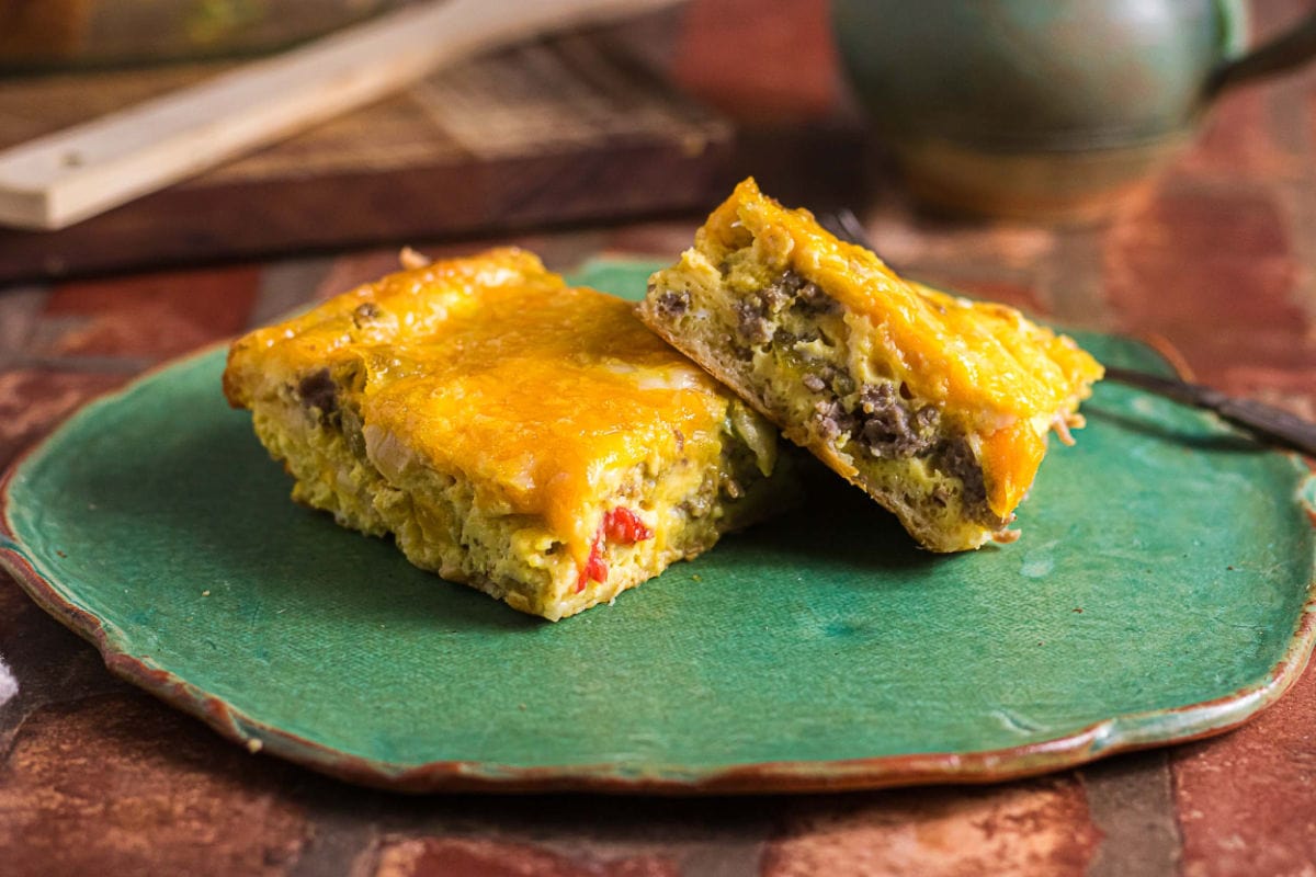 Two servings of crescent roll breakfast casserole on a green plate.