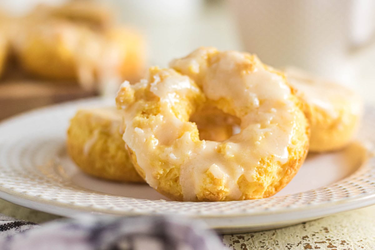 Glazed sour cream baked donuts arranged on a white plate with a soft, cake-like texture.