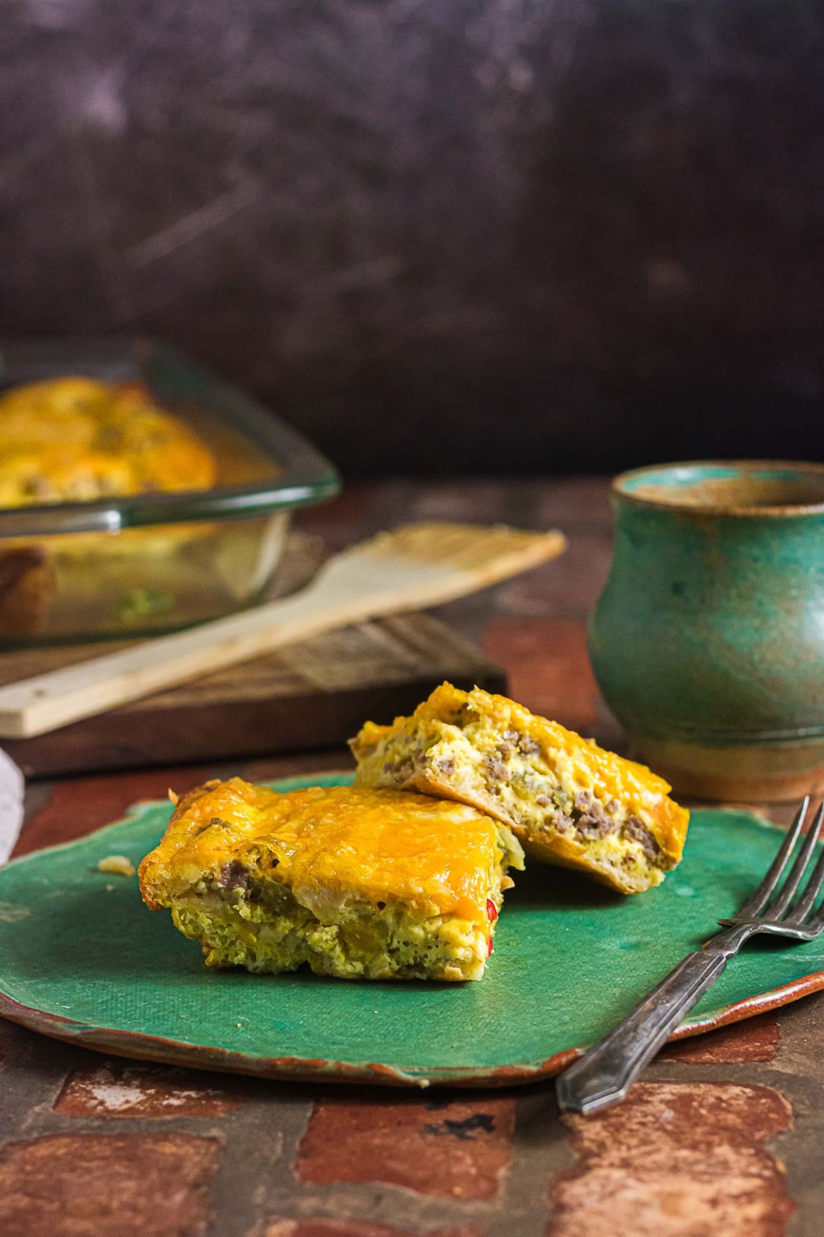 Crescent roll breakfast casserole with sausage, eggs, peppers, and cheese served on a green plate