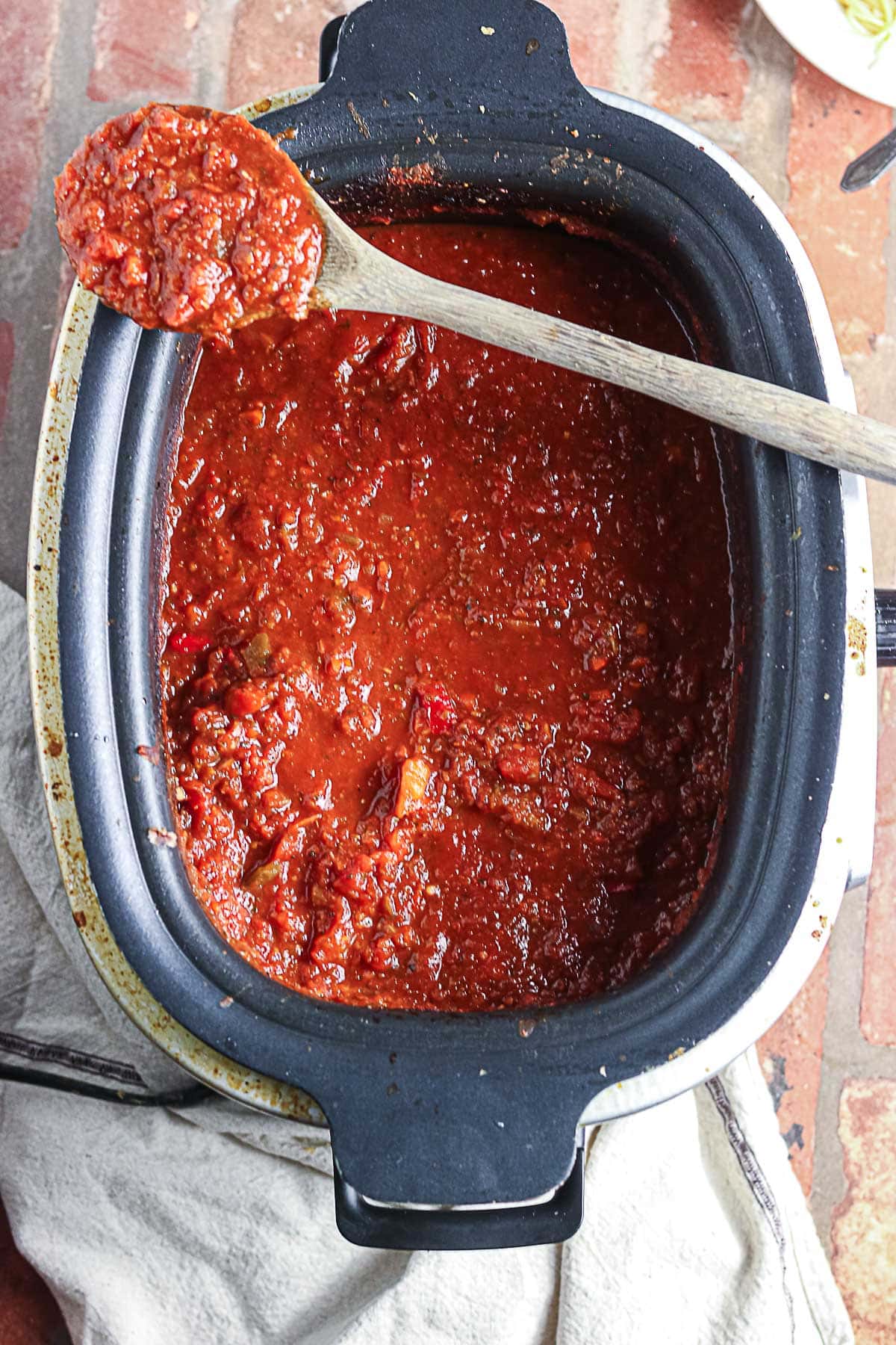 Overhead view of the slow cooker with the spaghetti sauce inside it.