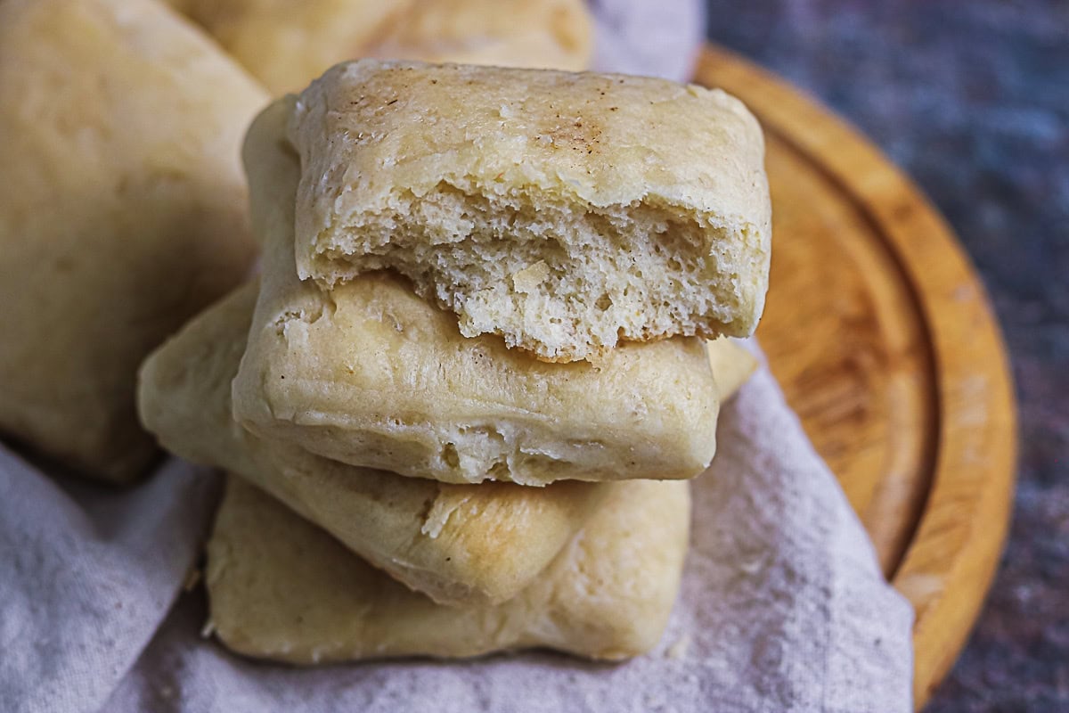 Soft homemade Texas Roadhouse rolls with a torn roll showing the fluffy interior