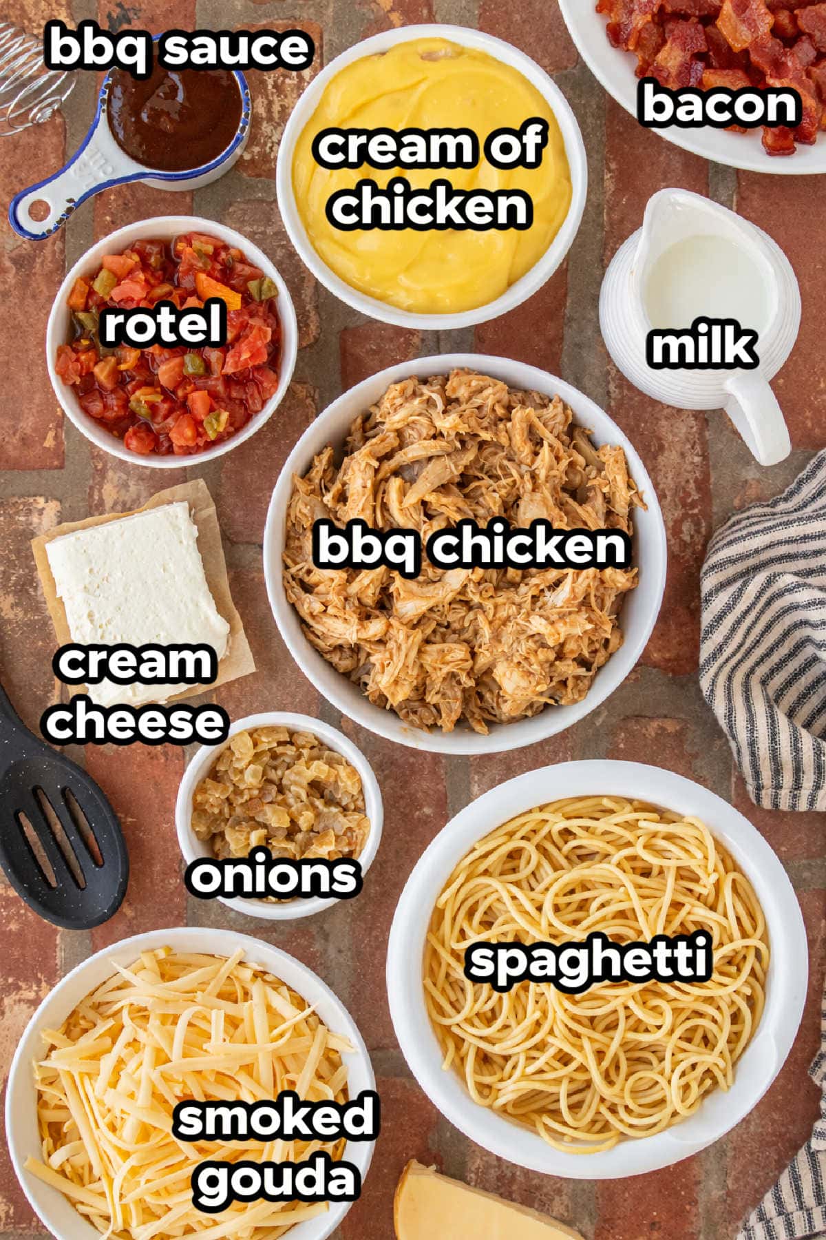 Ingredients for BBQ chicken spaghetti including shredded BBQ chicken, spaghetti, smoked Gouda, Rotel, cream cheese, cream of chicken soup, milk, onion, and BBQ sauce