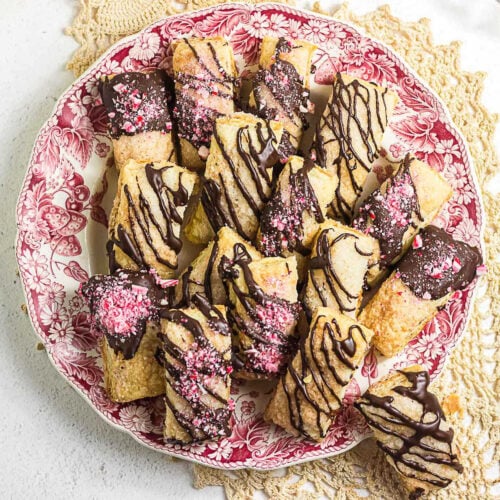 Easy chocolate peppermint puff pastry cookies arranged on a red and white holiday plate.