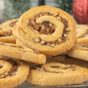 Close-up of a golden brown date nut pinwheel cookie with a spiral of chopped dates and pecans.