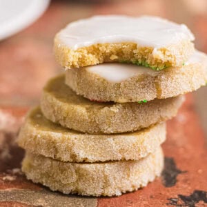 Brown butter icebox cookies stacked with a bitten iced cookie showing the crumb
