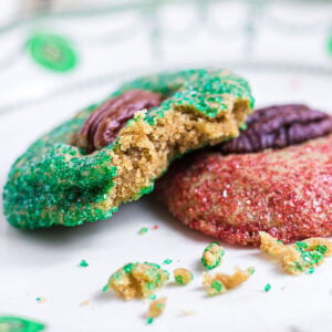 Close-up of a broken brown sugar butter cookie showing its tender golden center, crisp edges, and green sparkling sugar coating.