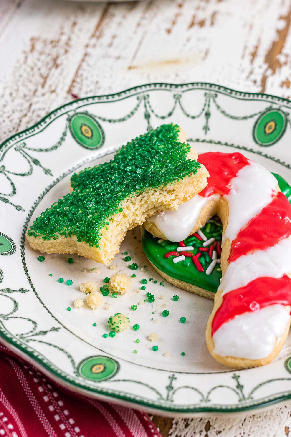 Close-up of a bitten Christmas sugar cookie showing its tender, buttery interior beneath sparkling green sugar.