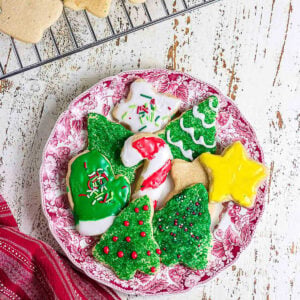 Festive Christmas sugar cookies shaped like trees, stars, candy canes, and mittens with colorful icing and sprinkles.