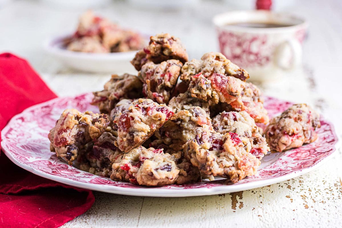 A plate of homemade fruitcake cookies with golden edges, chewy candied fruit, dates, and crunchy pecans, ready for Christmas.