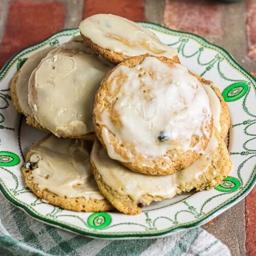 Coffee-glazed mincemeat cookies stacked on a decorative green and white plate.