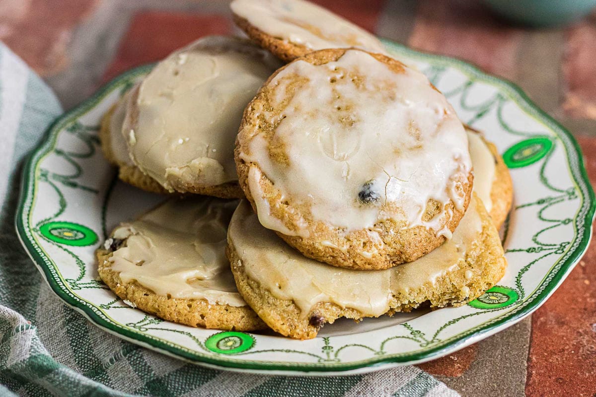 Close-up of homemade mincemeat cookies with creamy coffee icing on a vintage serving plate.