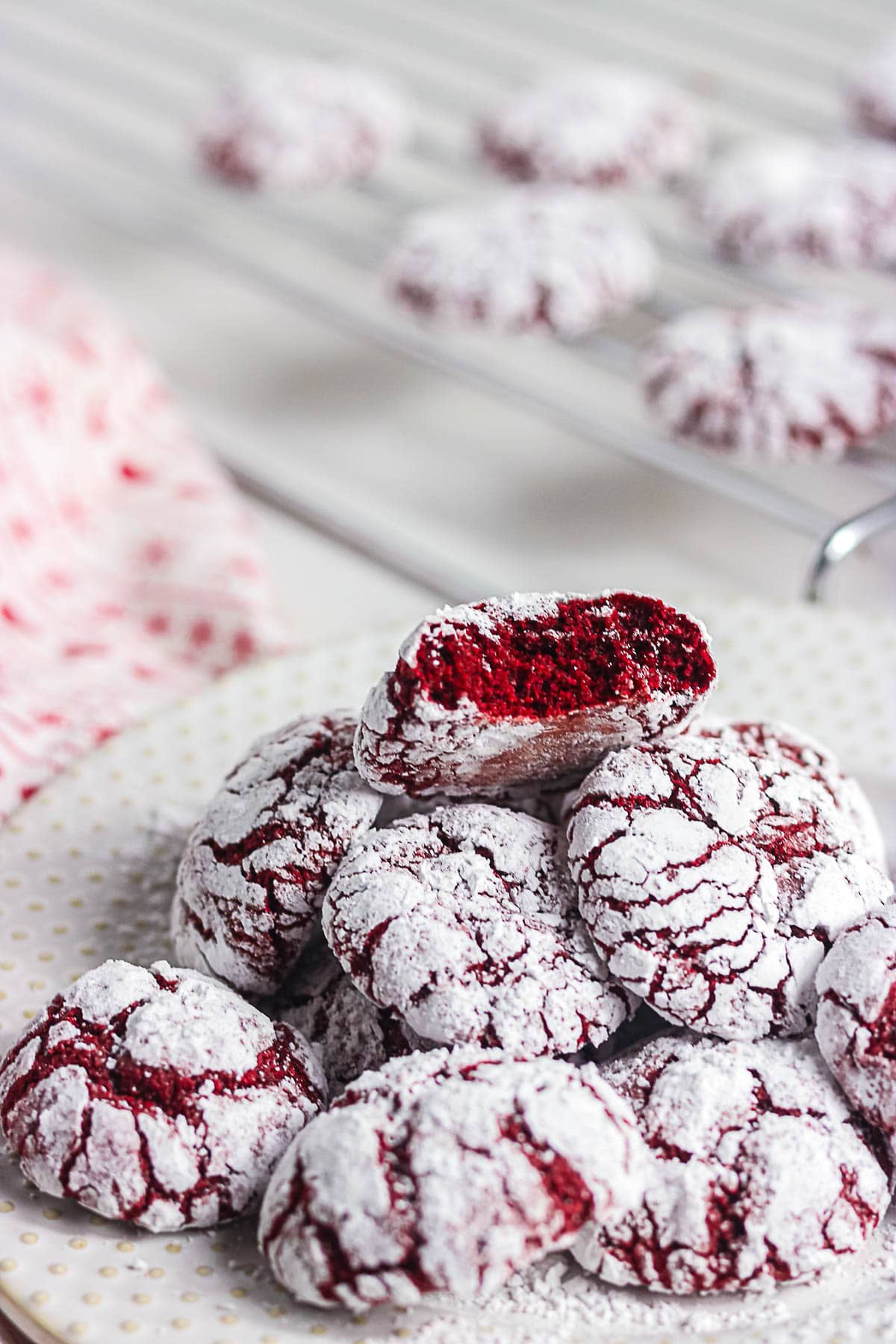 Red velvet crinkle cookies with one broken open to show the soft fudgy center