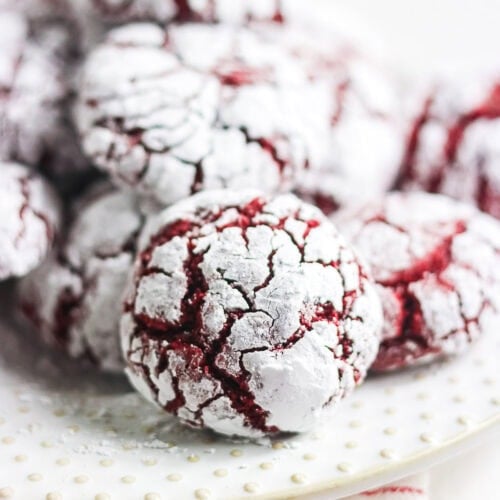 Close-up of a red velvet crinkle cookie with powdered sugar and deep red cracks