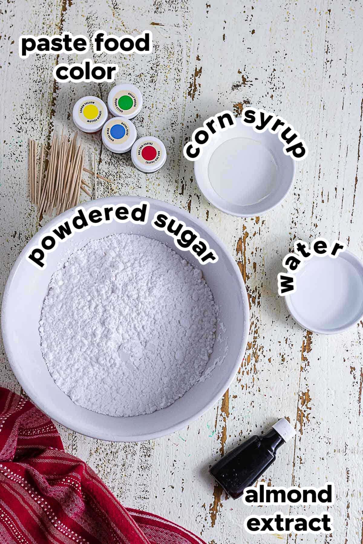 Ingredients for homemade sugar cookie glaze including powdered sugar, corn syrup, water, almond extract, and paste food coloring